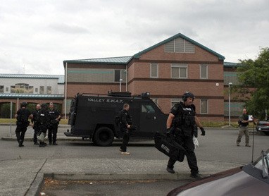 A Valley SWAT unit returns to the staging area at McKnight Middle School after a Kent man surrendered after a standoff with police.