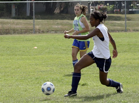 Senior Fabiana Stapleton pushes the ball upfield during a drill at practice. Senior captain Taylor Hoover pursues.