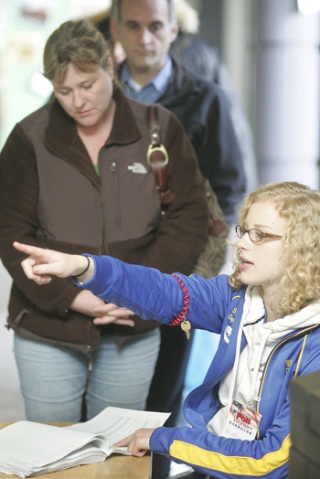 Hazen High School senior Brittany Granger directs Tina Storms of Renton to her precinct check-in at a poll the high school Tuesday. Five Hazen students volunteered at that location.