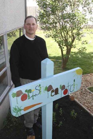 Kevin Pearson stands in a bed at the entrance to the community garden under development at St. Luke’s Episcopal Church in downtown Renton. Pearson is the rector of St. Luke’s. The church is holding a planting party this Sunday.