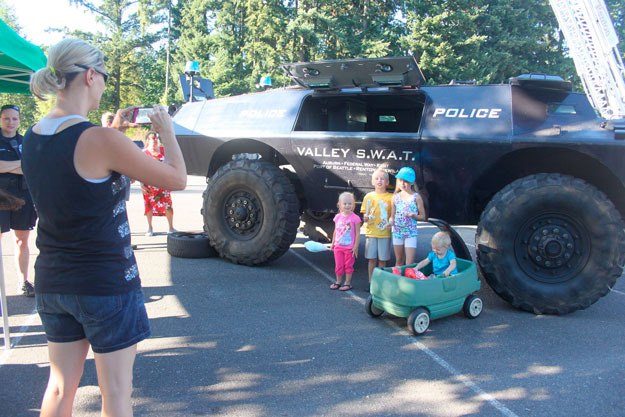 A parent takes a photo of kids with a police vehicle during National Night Out 2014.