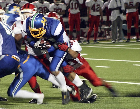 Hazen’s James Holland pushes through Renton defenders in a Sept. 25 win. Holland rushed for two long touchdowns in the game.