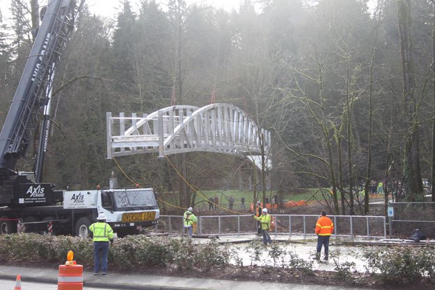 Workers lower the new Riverview Park Bridge into place on Friday.