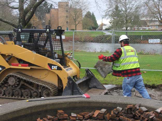 Workers remove concrete form a portion of the Upper Cedar River Trail near the Renton Senior Activity Center.