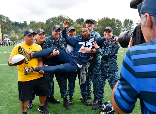 Micheal Bennett poses for a photo with members of the military during a break at Seahawks Training Camp