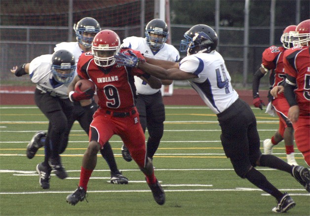 Renton's Justin Bennett fends off a Falcon defender in the Indians game against Thunder Mountain Sept. 10.