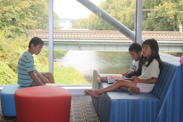 New seating areas by the floor-to-ceiling windows that overlook the river proved a popular spot for readers of all ages to take a break and enjoy the new library during Saturday’s grand opening celebration.