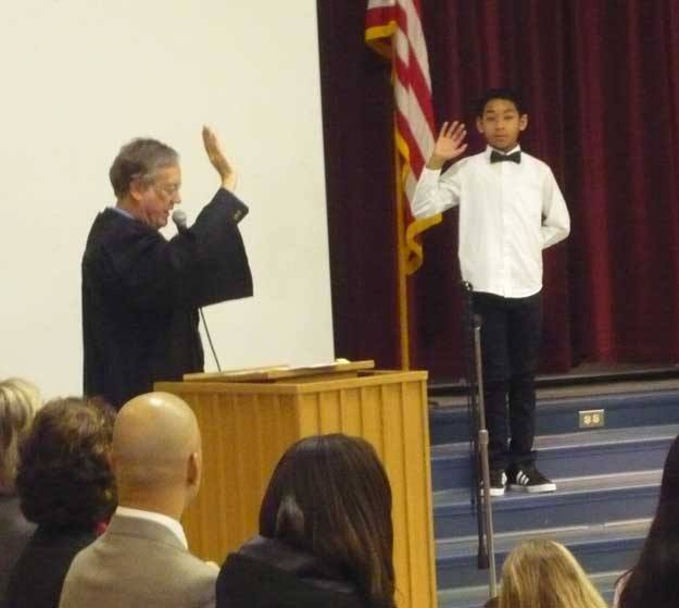 Fifth-grader Nico McMillan gets sworn in by judge Robert McBeth as Talbot Hill Elementary School's MicroSociety president.