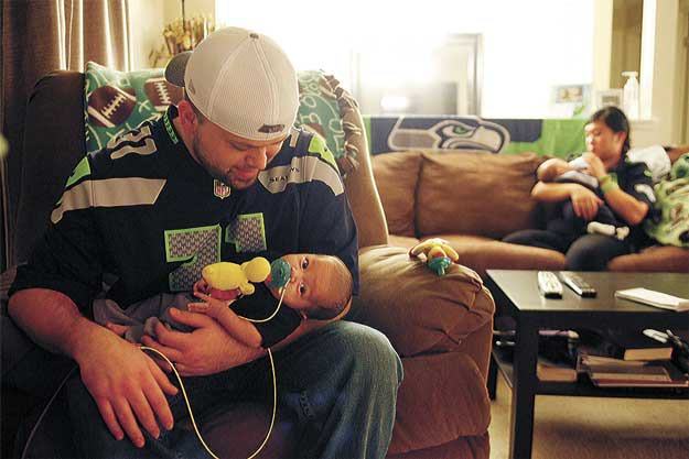 Dave and Kristina Quick hold their 8-week-old twins Franklin (left) and Harrison at their home in Brier.  Complications with Franklin’s health when the twins were born led to an extended stay at Seattle Children’s Hospital.