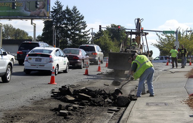 City of Renton public works workers helped clean up chunks of ashalt Friday morning that spilled from a Lakeridge Paving Co. truck at the intersection of Carr Road and 108th Avenue Southeast. The right lane of eastbound Carr Road was closed for a time. Lakeridge provided the heavy equipment.