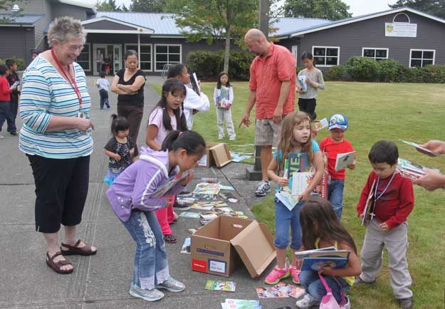 Highlands Elementary School Principal Janet Fawcett and Assistant Principal Alfred Deblasio watch as kids swarm a a delivery of books from their bookmobile at the Highlands Community Recreation Center.