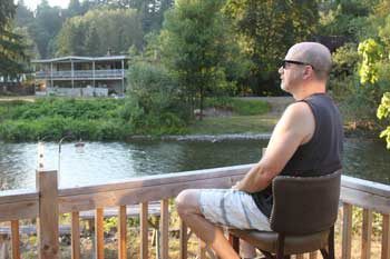 Gary Evett sits on his back porch watching the Cedar River. After 18 years in this location