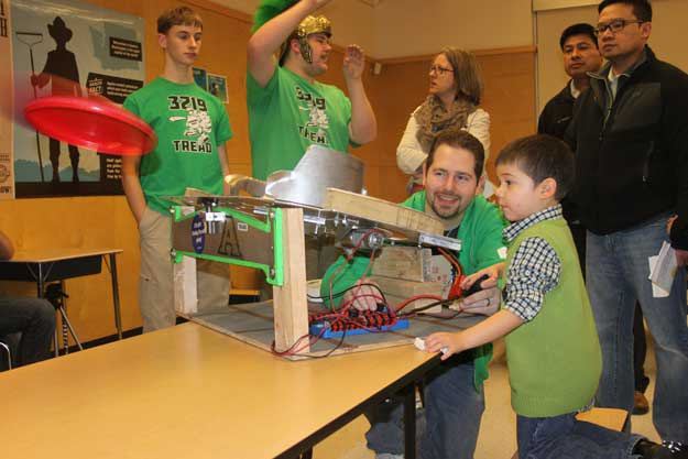 Chris Zawislak of Auburn High's First Robotics Club demonstrates a Frisbee shooter for students at Honey Dew Elementary School's Science Night.