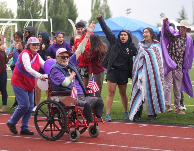 Walkers waiting to take their turn on the track cheer during the survivor lap that opened the 2016 Relay for Life in Renton.