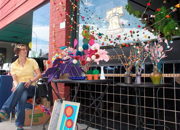 A vendor at last year's Art and Antique walk shows off her wares.