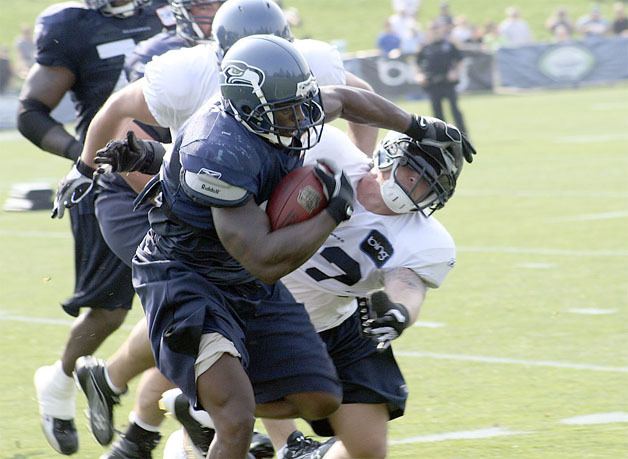 Seahawks running back Julius Jones stiff arms a defender during training camp drills August 5.