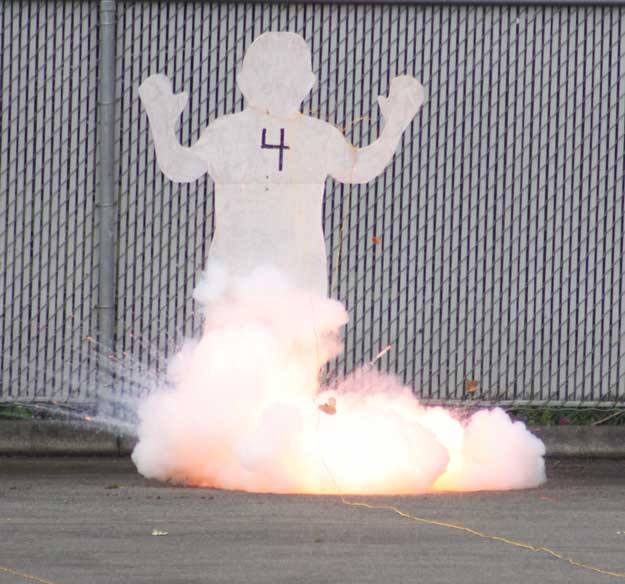 The launching charge of a professional grade firework blows the foot off of a plywood silhouette.