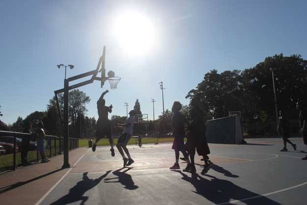 A group of ballplayers take advantage of the warm weather and late sun Tuesday to play a game of pick-up basketball at Liberty park.