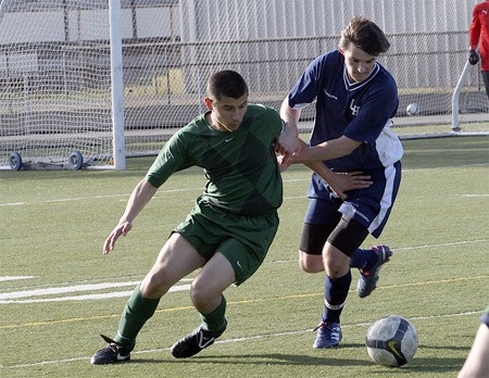 Lindbergh senior Steven Thorkildson battles an Evergreen defender for the ball April 13.