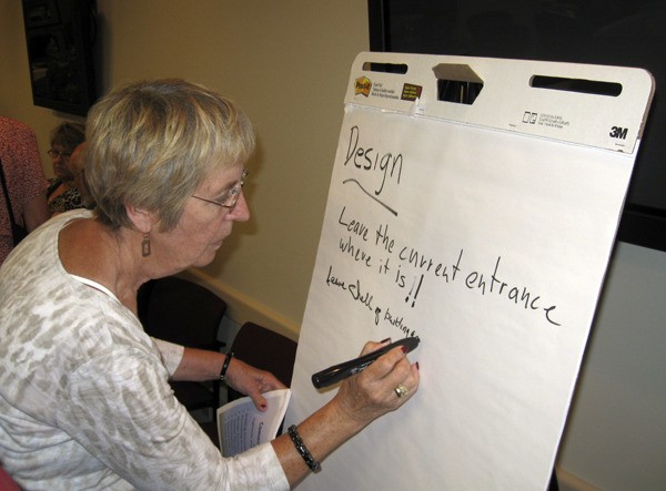 Sandra Polley of Renton writes down her idea for the design of the new Cedar River library Tuesday night