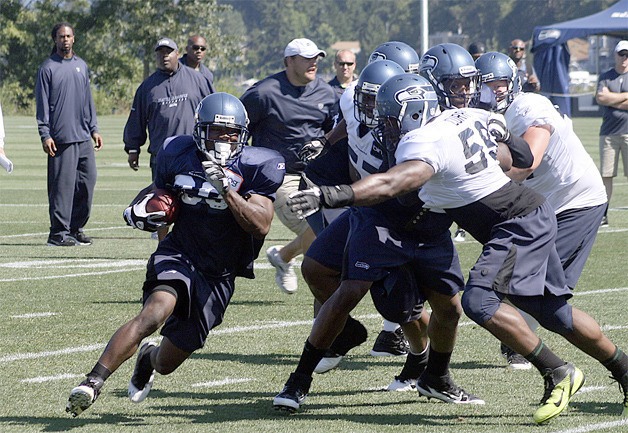 Seattle running back Justin Forsett rushes around the line at practice Aug. 1.