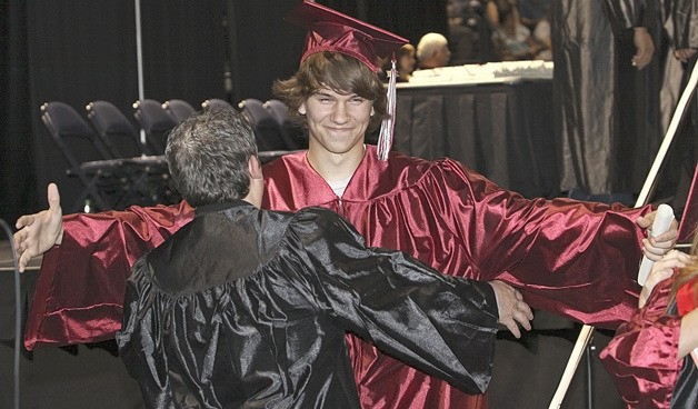 Anesthesia technician graduate Reese Fobes hugs his instructor Gary West after walking across the stage Thursday during the Renton Technical College graduation ceremony at ShoWare Center.