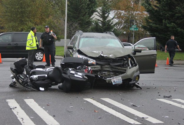 mayor Denis Law talks with a police officer at the scene of an accident that sent an Renton police officer to the hospital on Monday.