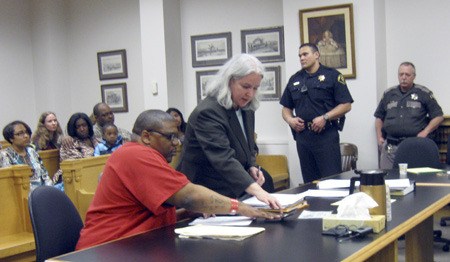 Attorney Ann Mahony helps convicted murderer Curtis Walker take fingerprints Wednesday after he was convicted of first-degree murder in the death of 12-year-old Alajawan Brown of Skyway. In the background are Alajawan's parents