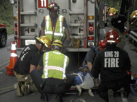 Fire crews with Renton Fire and Life Safety and King County Fire District 20 in Skyway treat a man early Monday morning who had fallen over a guardrail and was rescued with ropes on Monster Road.