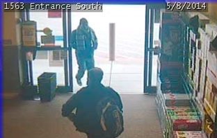 Police released this image of the suspect (walking out of the door) on an armored car robbery.