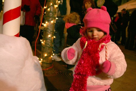 Madison Reitz examines a candy can at the tree lighting festival in downtown Renton at the piazza. A couple hundred people attended the event Saturday night.