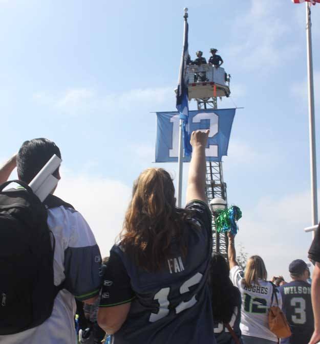 Seahawks fans cheer the 12th Man flag after it was raised at City Hall Thursday.