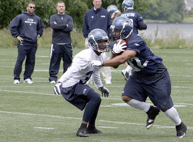 Seahawk running back Quinton Ganther runs around cornerback Roy Lewis at a June 15 practice.