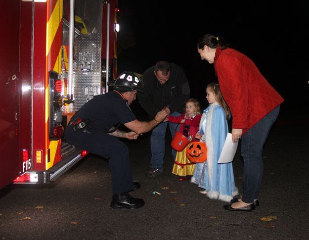 A family collects candy from a firefighter during the city's annual Truck or Treat Oct. 23 at the Community Center.