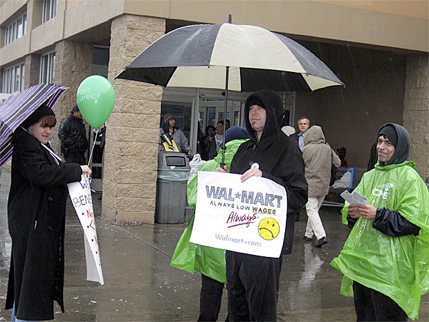 Melvin Neifert (center) stands with Amanda Everly and another citizen protesting unfair labor practices at the Renton Walmart on Black Friday.