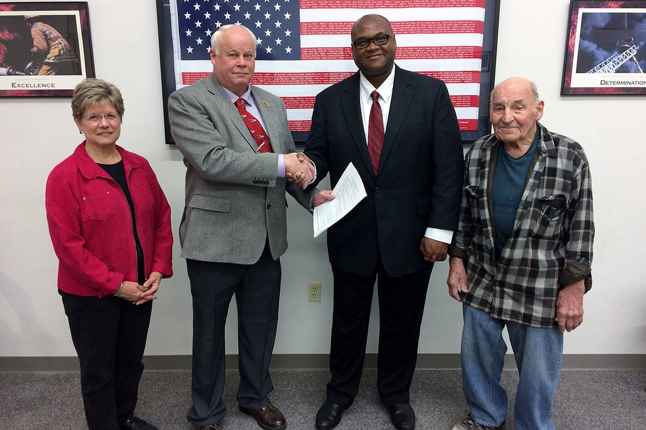 Chief Eric Hicks, third from left, accepts a job offer on May 15 from KCFD 20 Chairman Terry, second from left. Also pictured are Cynthia Lamothe,left, and Gene Lux, far right. Courtesy photo