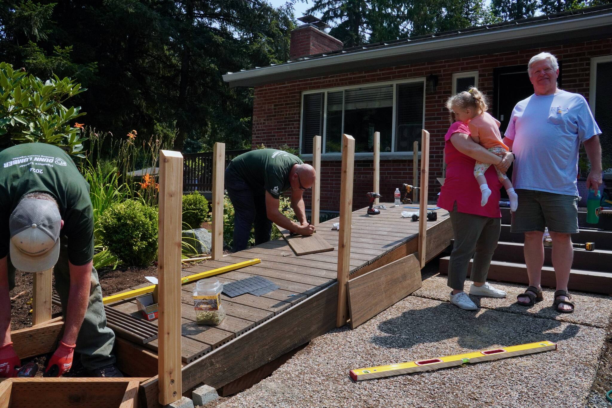 Corin Goodwin and Robert Goodwin with their granddaughter as her new ramp gets built. Photo by Joshua Solorzano/Renton Reporter