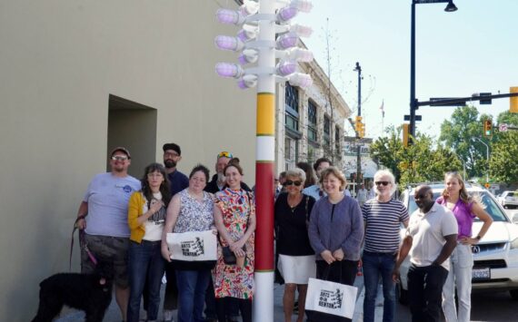 Renton Arts Commission members, various Renton employees, and a few council members gathered around the renewed streetlight. Photo by Joshua Solorzano/The Reporter