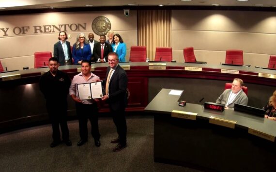 Business owner Isidro Rojas with the Renton City Council taking a photo with the Hispanic Heritage Month proclamation. (Screenshot from the Renton City Council meeting)