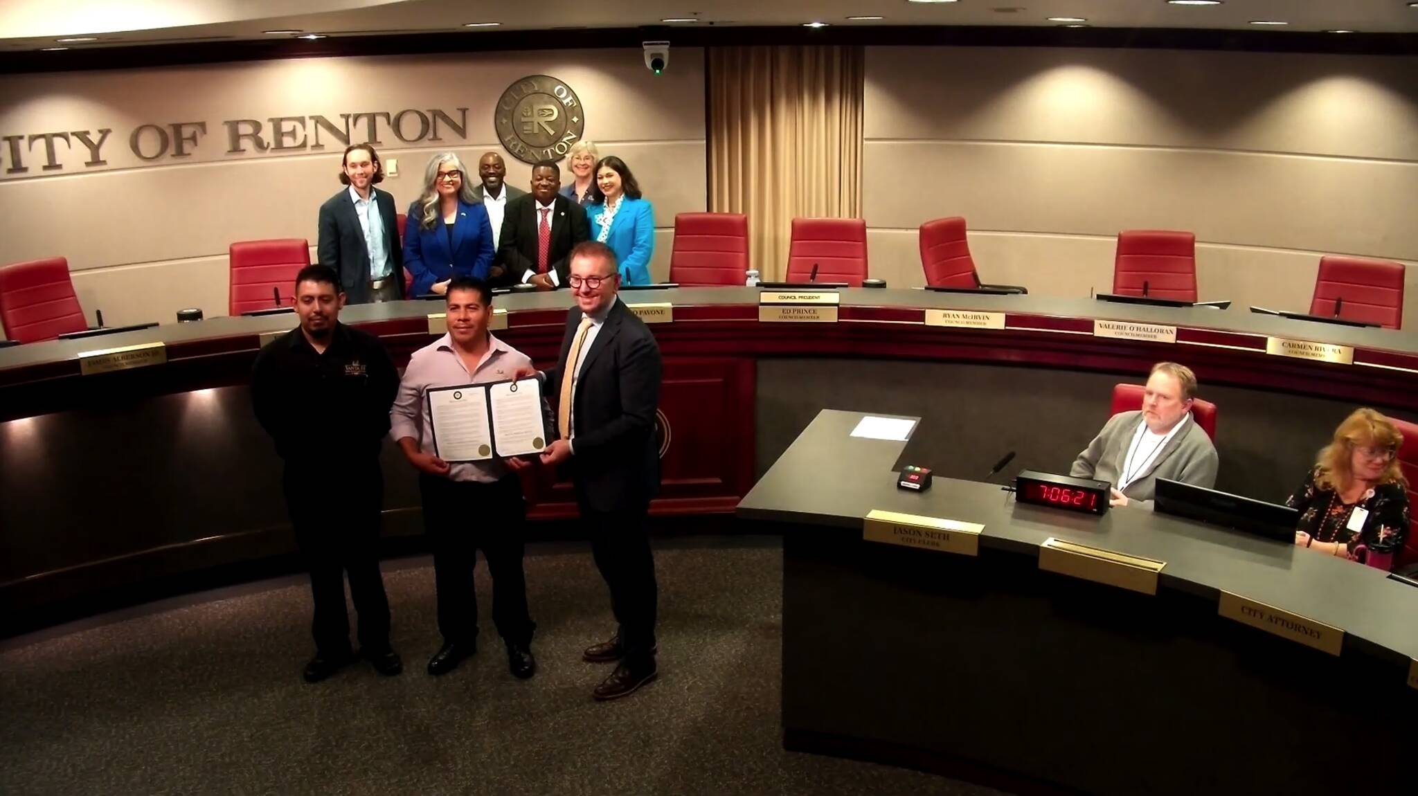 Business owner Isidro Rojas with the Renton City Council taking a photo with the Hispanic Heritage Month proclamation. (Screenshot from the Renton City Council meeting)