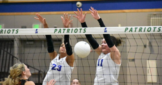 Julianne Lee (11) and Kendreah Beazer (23) combine for a block against Newport. Ben Ray / The Reporter