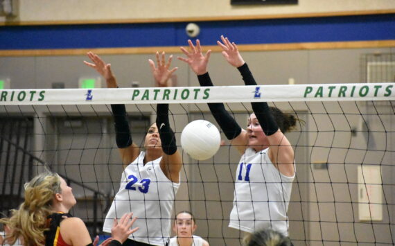 Julianne Lee (11) and Kendreah Beazer (23) combine for a block against Newport. Ben Ray / The Reporter