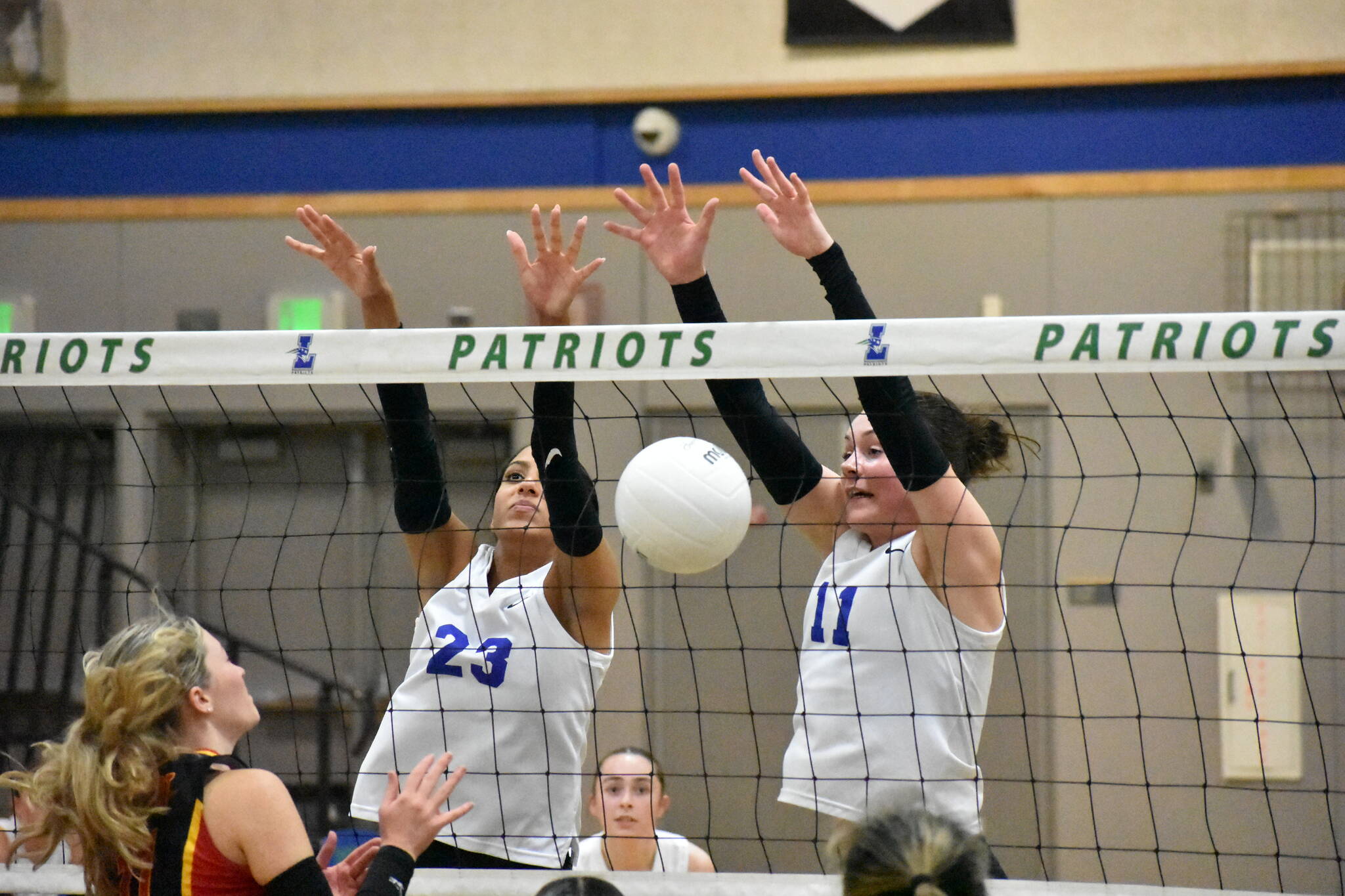 Julianne Lee (11) and Kendreah Beazer (23) combine for a block against Newport. Ben Ray / The Reporter