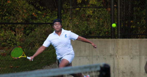 Liberty senior Alex Tran looks to return a volley in his tightly contested doubles match. Photo taken by Alexis Phung