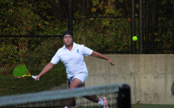 Liberty senior Alex Tran looks to return a volley in his tightly contested doubles match. Photo taken by Alexis Phung