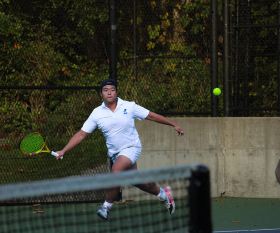 Liberty senior Alex Tran looks to return a volley in his tightly contested doubles match. Photo taken by Alexis Phung