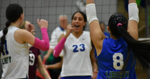 Charlize Espinosa throws her arms in the air after a Kendreah Beazer spike against Mercer Island. Ben Ray / The Reporter