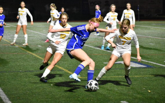 Morgan Ackermann controls the ball between two Inglemoor defenders. Ben Ray / The Reporter