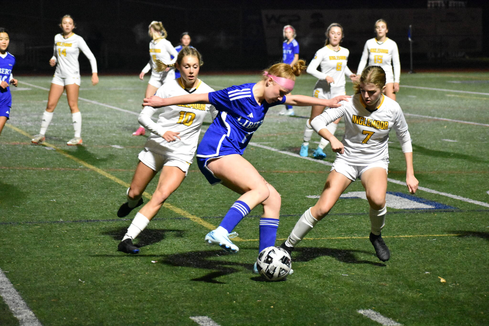 Morgan Ackermann controls the ball between two Inglemoor defenders. Ben Ray / The Reporter