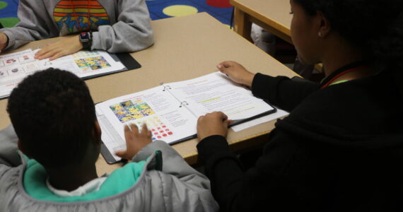 Before reading begins, coaches check-in with students on how their doing with little workbooks. Photo by Bailey Jo Josie/Sound Publishing.